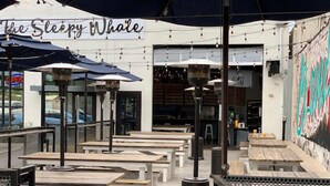 An outdoor seating area with tables and umbrellas at 'The Sleepy Whale'. - Modern Chandler Home - Heated Pool, Golf, Fire Pit (Chandler)
