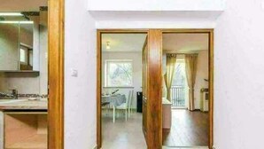 A hallway with wooden doors leading to a dining area and a balcony. - Apartments Nika (Vinodol)