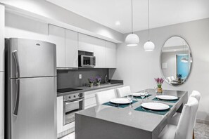 Een magnetron, een blender, kookgerei, borden en bestek