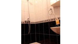A bathroom with a bathtub, a sink, and a shower. - Apartmani Krka Rooms (Sibenik)