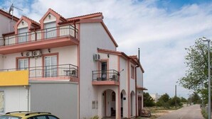 A multi-story residential building with balconies, air conditioning units, and a yellow awning. - Apartmani Krka Rooms (Sibenik)