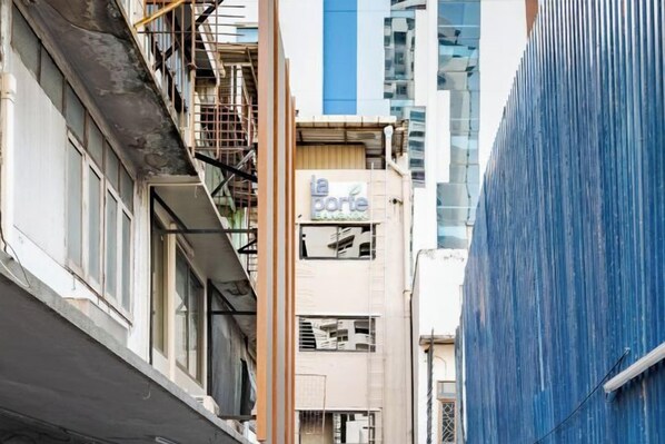 A narrow urban street with buildings, one with a sign reading 'la porte.'
