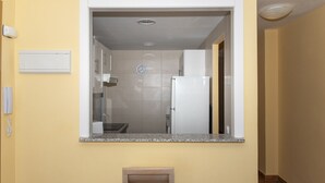 A narrow hallway with a kitchen area visible through a doorway. - FRONTALMAR, ESC-B, 8º-32 (Cullera)
