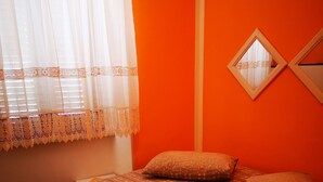 Una cama con una colcha estampada, dos almohadas y dos toallas dobladas.