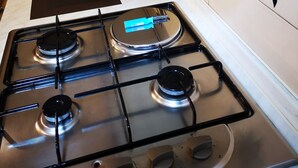 Una cocina con estufa a gas, un fregadero y un tostador.
