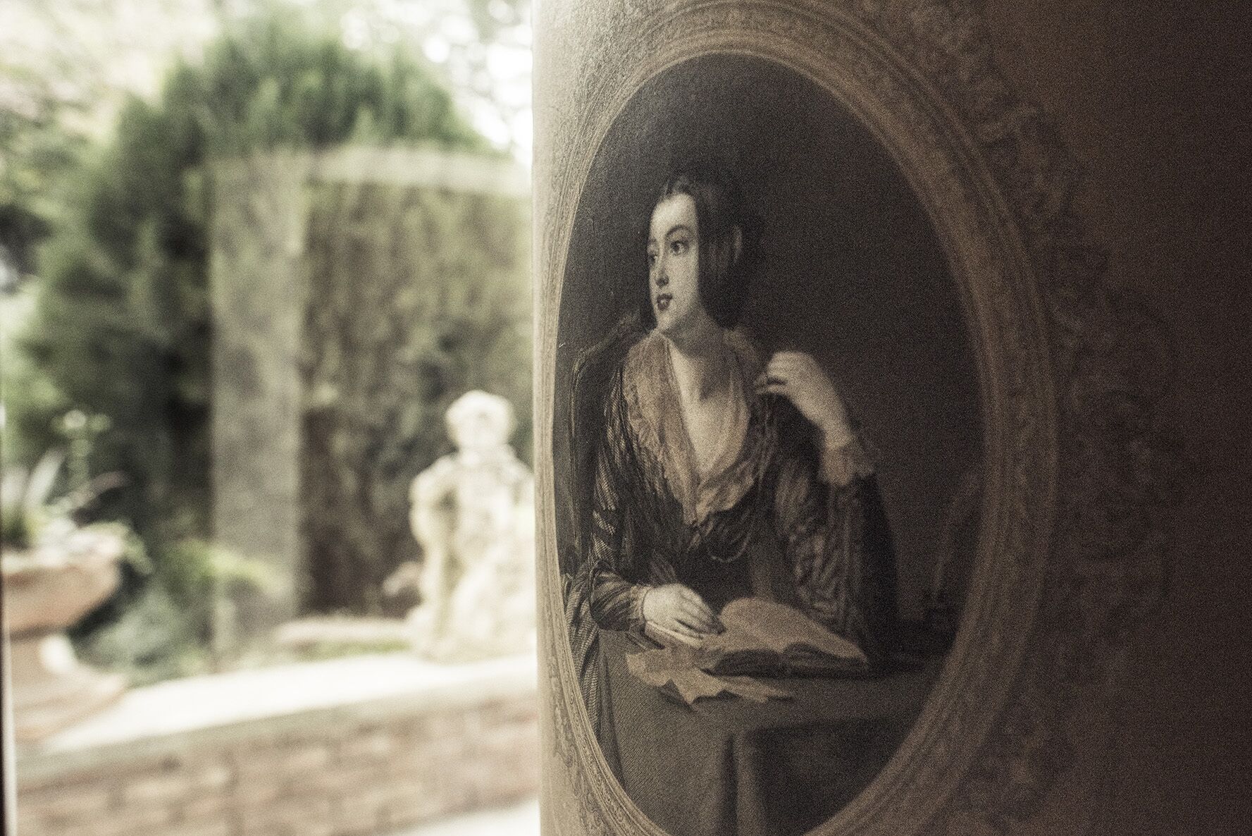 A classical statue in a garden setting.