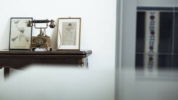 A vintage typewriter on a wooden table with two framed pictures beside it.