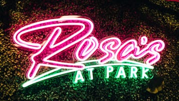 En neonskilt med teksten "Losa's at Park" i kursiv skrift.