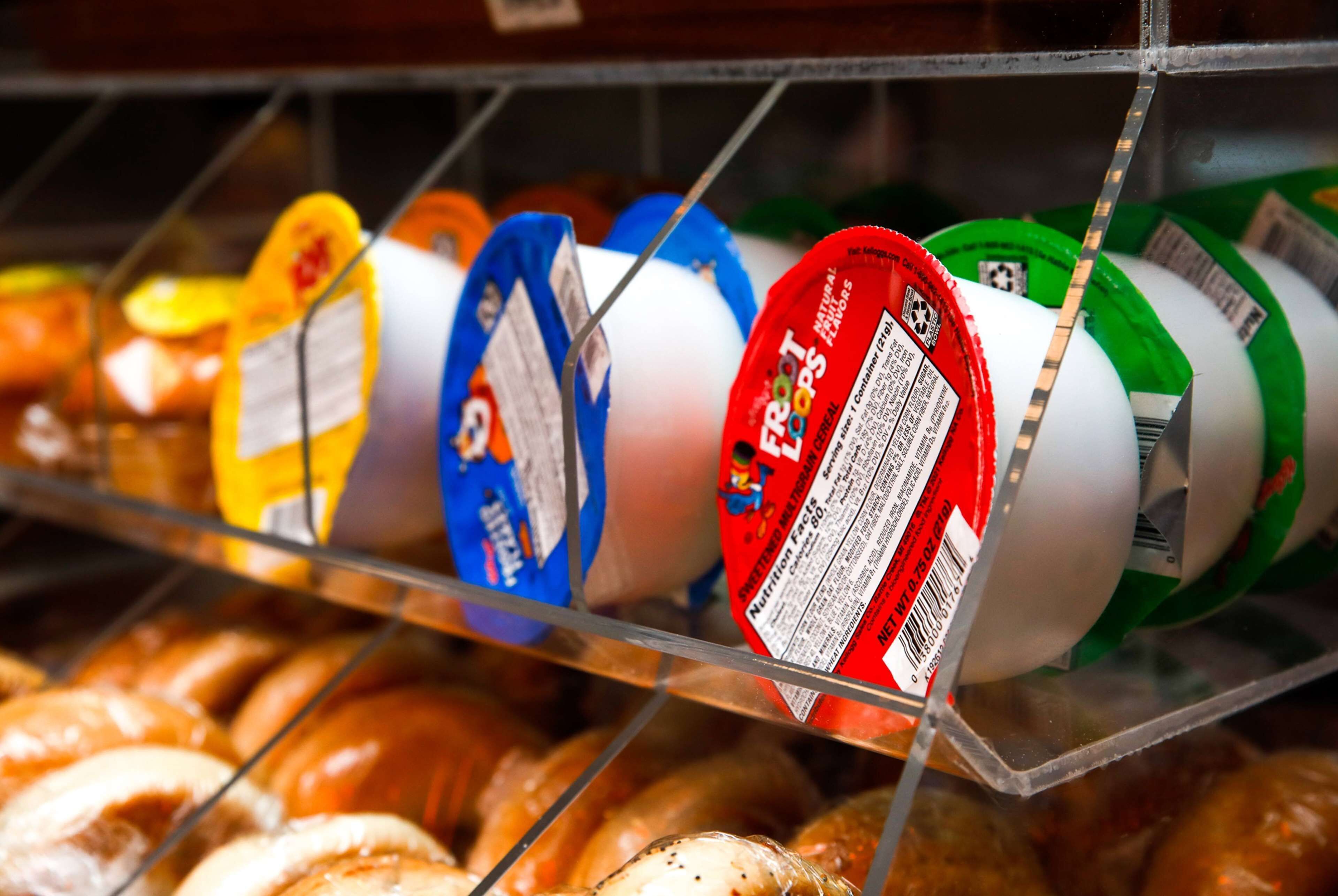 A refrigerated display of various yogurt products in a store.