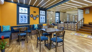 A dining area with wooden furniture, a blue sofa, and a staircase leading to an upper level. - Wonder Wood Hotel (Istanbul)