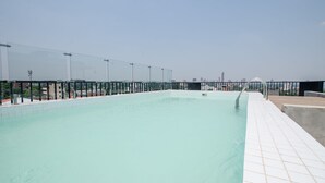 Une piscine sur le toit offrant une vue dégagée sur les gratte-ciel de la ville.