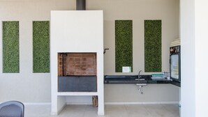 Eine moderne Küche mit eingebautem Kamin, einem Spülbecken und vertikalen, grünen Gärten an den Wänden.