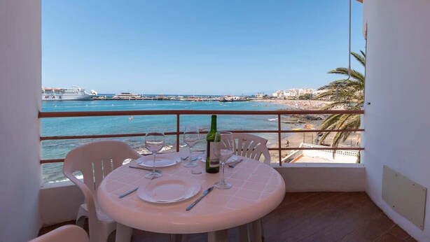 A balcony with a table set for two, overlooking a beach and the sea. - Cristianmar 3 - One Bed (Los Cristianos)