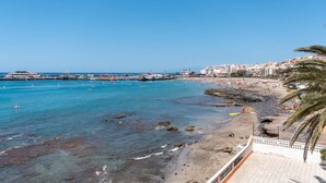 A coastal view with a beach, rocky shoreline, and a pier extending into the water. - Cristianmar 3 - One Bed (Los Cristianos)