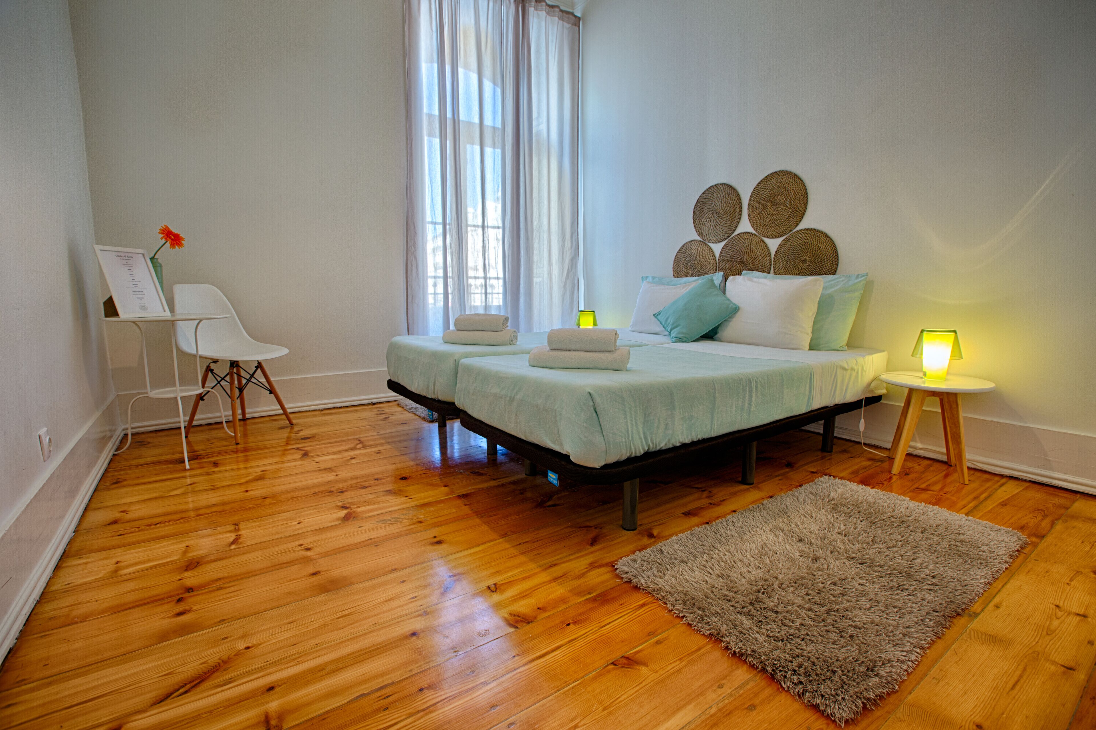 Un dormitorio con cama, lámparas de noche, una silla y una alfombra.