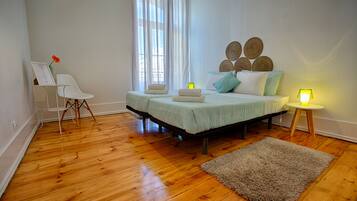 Un dormitorio con cama, lámparas de noche, una silla y una alfombra.
