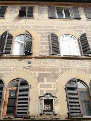 Un edificio con ventanas de arco y molduras decorativas.