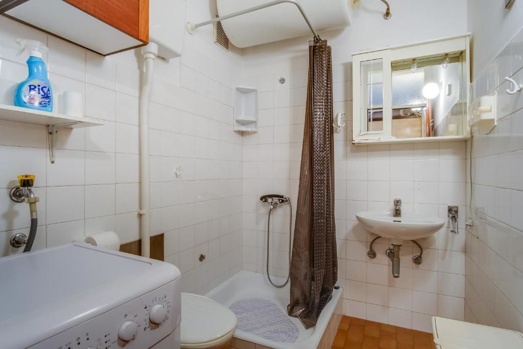 A bathroom with a bathtub, shower, toilet, and sink.