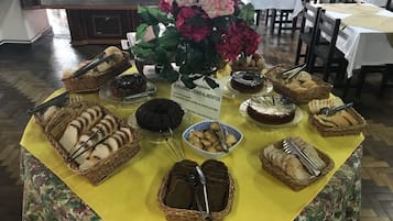 A buffet table with various food items and a sign prohibiting the consumption of food.