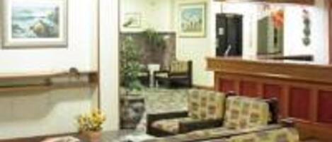 A lobby with a sofa set, a small table, and a wall-mounted television.