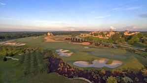 Un parcours de golf doté de bunkers, un club-house et un vaste domaine comprenant plusieurs bâtiments.