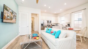 A modern kitchen with white cabinets, a stainless steel refrigerator, and a microwave. - Sea Breeze Cottage near Disney with Private Hot Tub & Margaritaville Resort &. (Kissimmee)