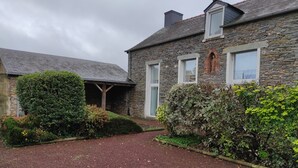 Una casa de piedra con camino de grava y un pequeño jardín.