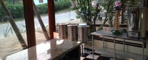A kitchen area with a granite countertop, stainless steel appliances, and a view through the window. - Hotel Warabi (Resende)