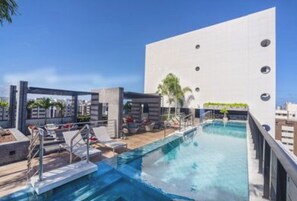 Relax by the pool surrounded by lounge chairs and umbrellas.