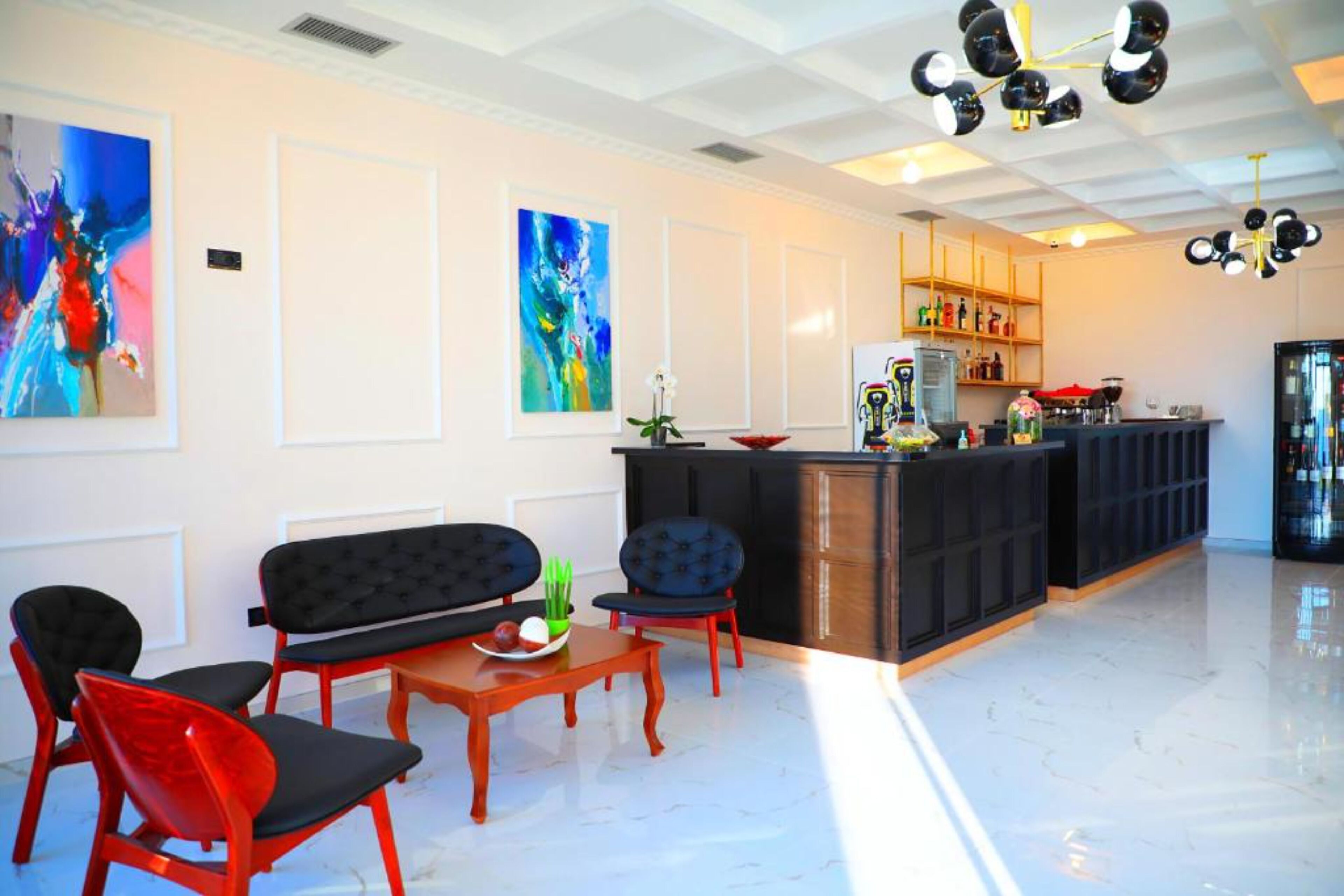 Un interior moderno con una zona de estar, una cocina y obras de arte en las paredes.