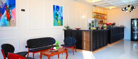 Un interior moderno con una zona de estar, una cocina y obras de arte en las paredes.
