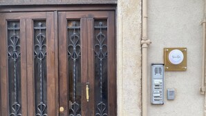 Una porta doppia in legno con grate metalliche decorative e una maniglia in ottone.