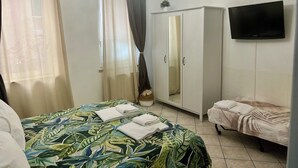 Una camera da letto con un letto, un armadio, una TV e uno specchio.