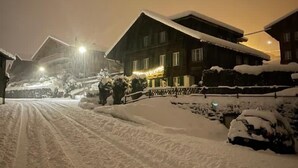 Une rue enneigée, bordée d’immeubles et illuminée par une enseigne.