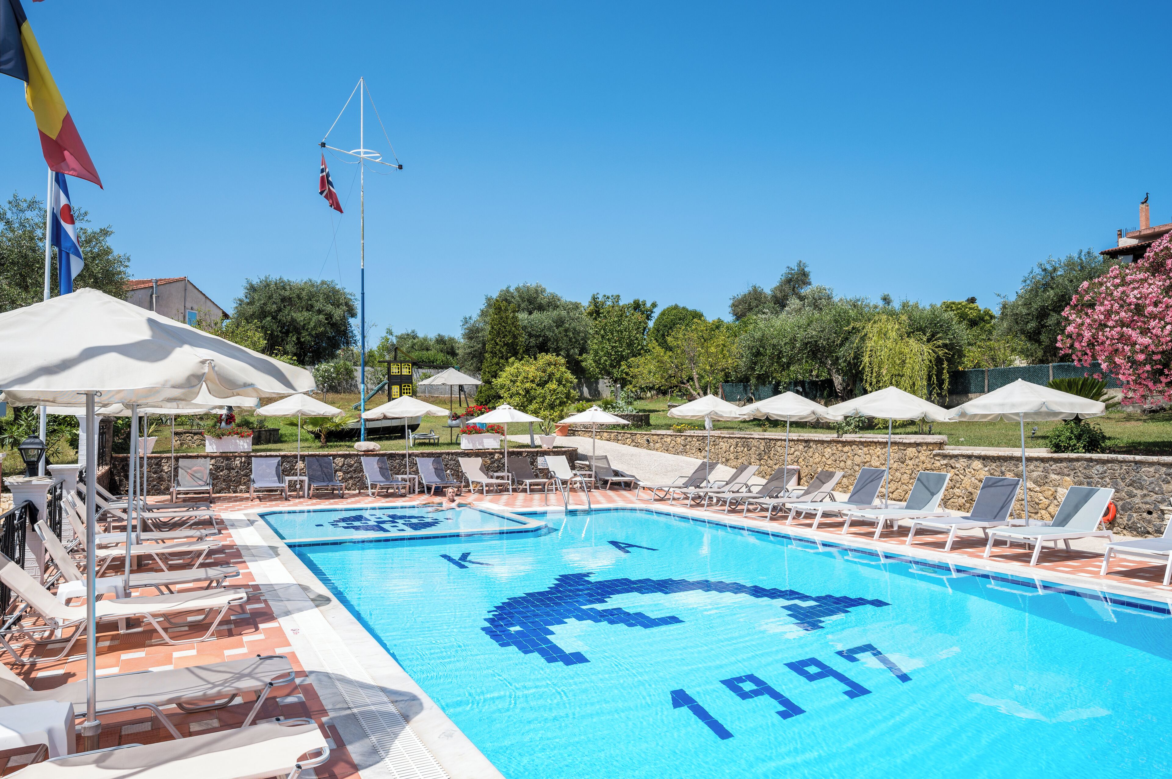 Una piscina al aire libre de temporada, sombrillas