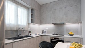 Una cocina moderna con un lavamanos integrado, electrodomésticos de acero inoxidable y una zona de comedor con mesa y sillas.