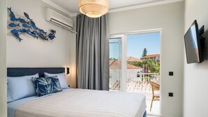 Un dormitorio con una cama grande, vistas al exterior, un televisor y aire acondicionado instalado en la pared.