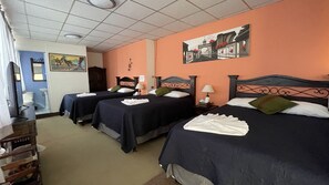 Habitación triple, varias camas, baño privado | Tabla de planchar con plancha y ropa de cama