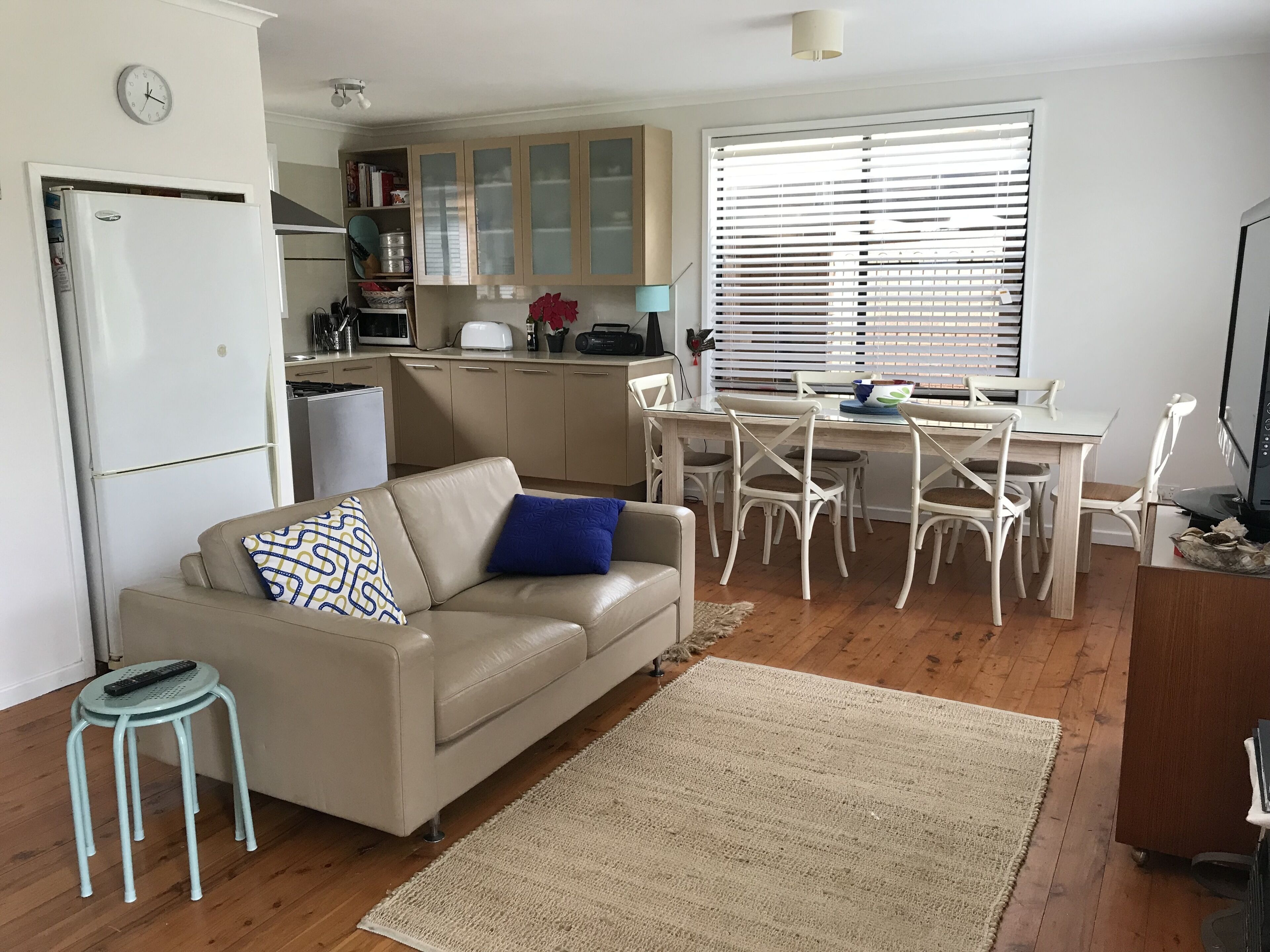 Open plan family, kitchen and dining room with 2 leather couches and Smart TV