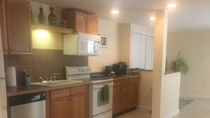 A kitchen with wooden cabinets, a microwave, a stove, and a dishwasher.