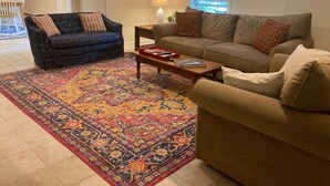 A living room with two sofas, a coffee table, and a patterned rug.