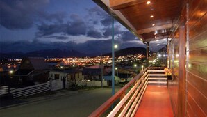 Een balkon met uitzicht op een stadsgezicht in de schemering.