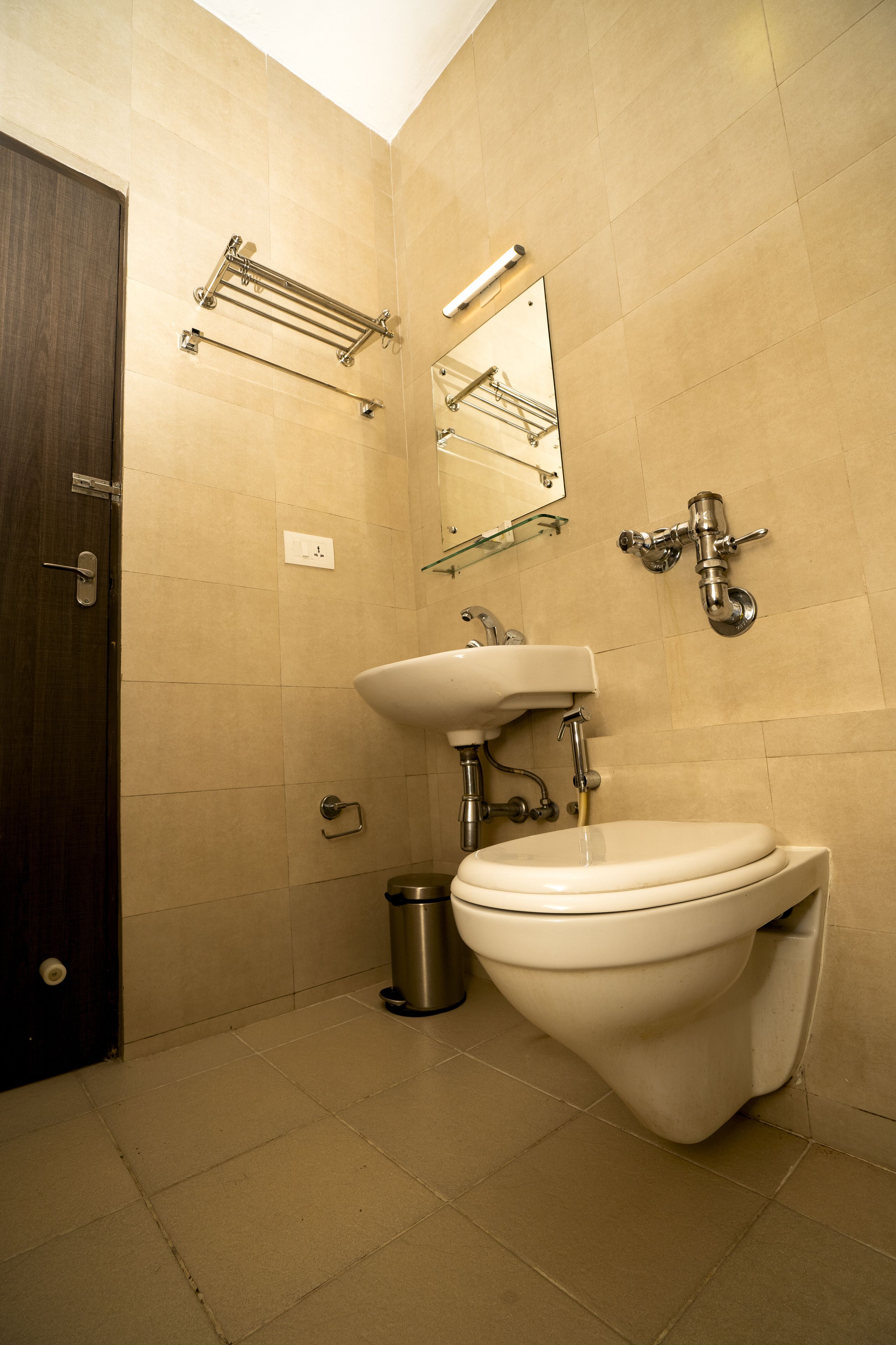 A bathroom with a toilet, sink, and mirror.