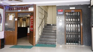 A restaurant entrance with a sign, a staircase, and a reception area with a 5-person elevator. - Hotel Maruthi Residency Inn (Hyderabad)