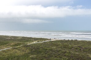 Een kustpad met uitzicht op de oceaan en het strand.