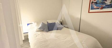 1 dormitorio y tabla de planchar con plancha