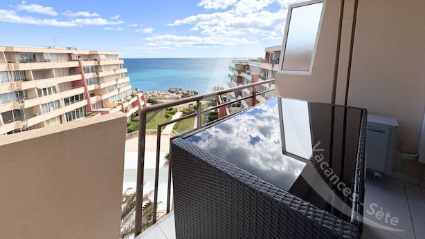 A balcony with a view of the sea and buildings.