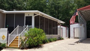 A motel with a covered porch, a staircase, and an American flag. - Steinhatchee Nest House (Steinhatchee)
