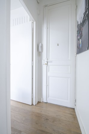Stylish hallway with a door leading to a space, featuring a keyhole and handle.