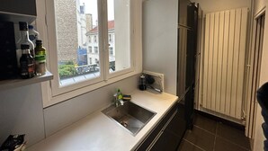 Cozinha moderna com janela, pia e radiador.